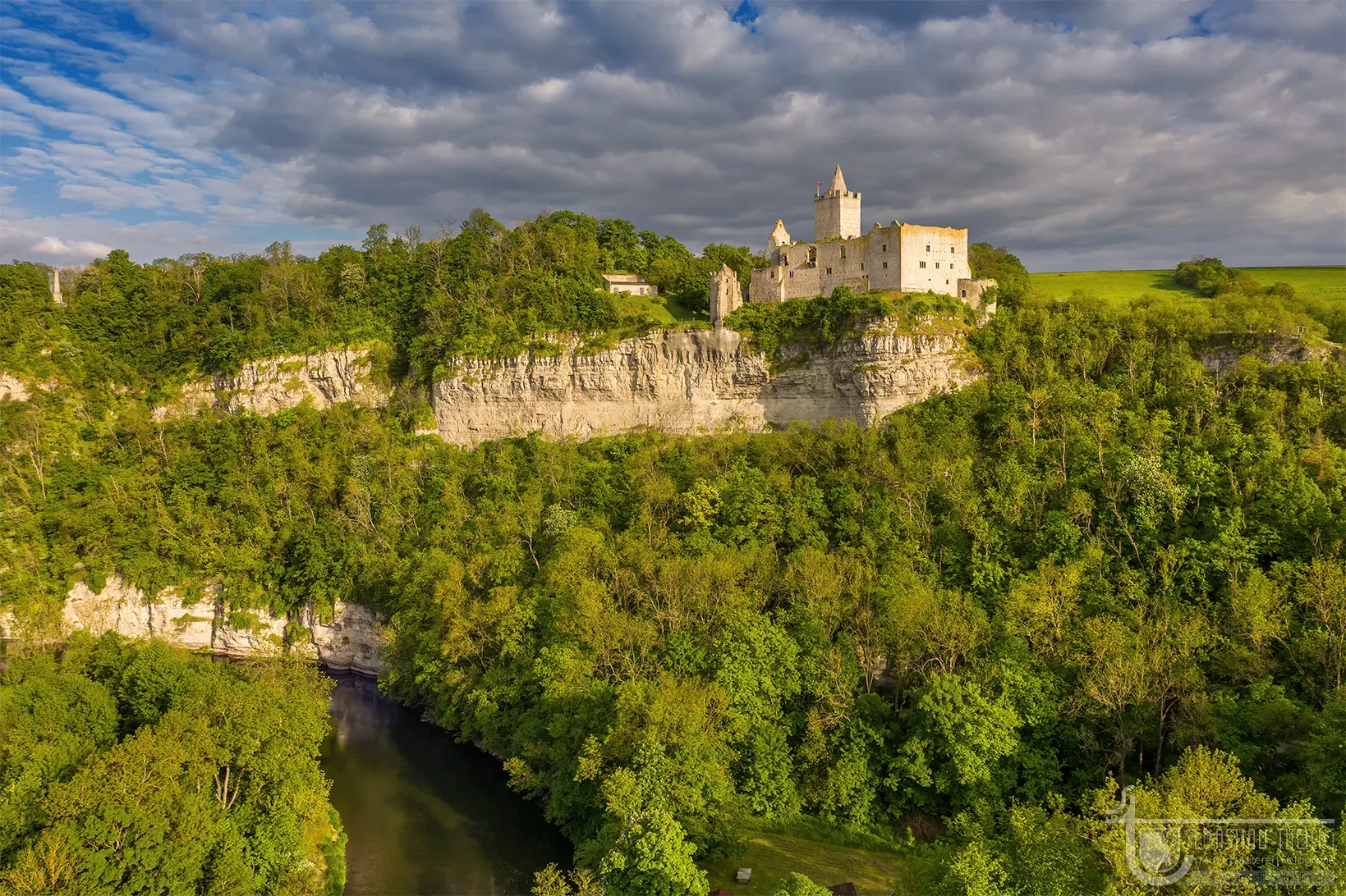 Burgruine auf einem weißen Felsen über einem Fluss