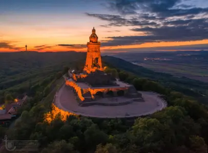 Orange beleuchteter Turm auf einem Berg
