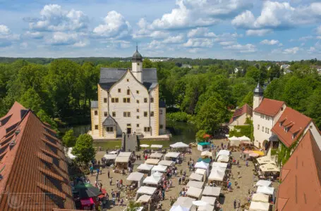 Schloss mit Markt in grüner Landschaft