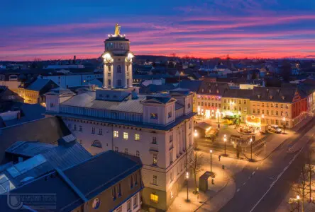 Abendrot mit beleuchteter Kleinstadt mit Rathaus