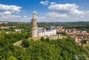 Burg in grüner Landschaft mit Kleinstadt
