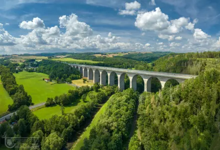Autobahnbrücke mit plastischen Wolken in grüner Landschaft