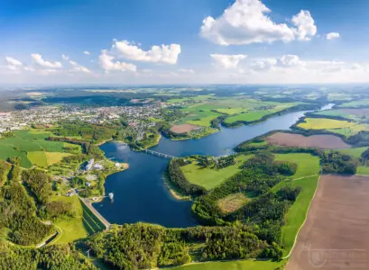 Luftbild eines Stausees in grüner Landschaft
