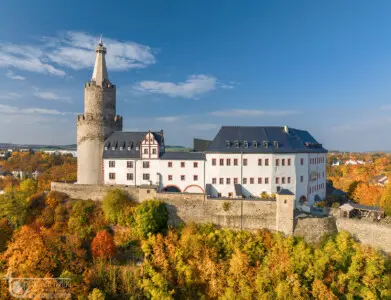 Burg mit großem Bergfried oder Turm im Herbst