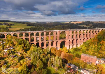 Eisenbahnbrücke mit Triebwagen der Vogtlandbahn im Herbst