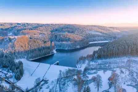 Reif, Eis und Schnee mit Stausee im Wald