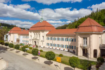Prächtiges Gebäude mit rotem Dach unter blauem Wolkenhimmel