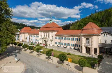 Prächtiges Gebäude mit rotem Dach unter blauem Wolkenhimmel