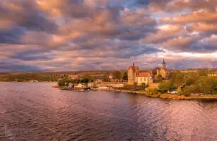 See mit Schloss und Sturmwolken
