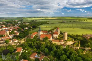 Luftbild einer burg mit grünen Feldern und roten Dächern