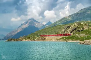 Rote Eisenbahn an See im Hochgebirge
