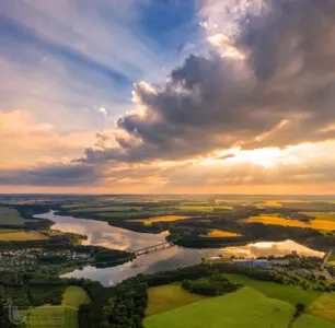 Sonnenstrahlen und Wolken über einem Stausee