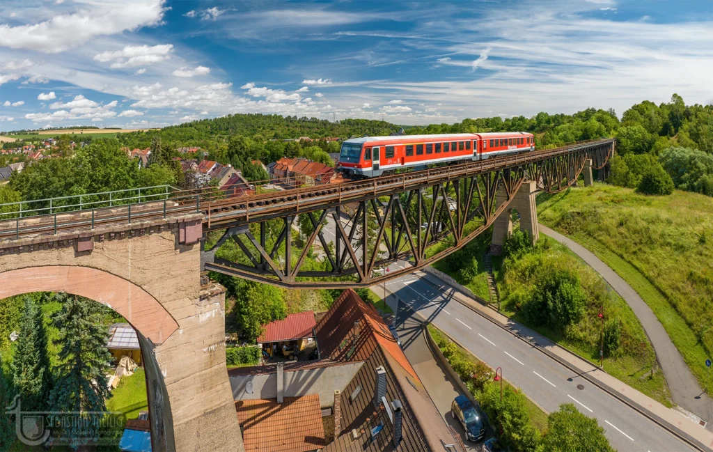 Roter Triebzug auf Eisenbahnbrücke